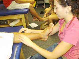 a student treats the ankle of an athlete