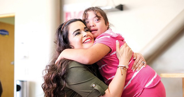 girl with Down syndrome hugging a teacher