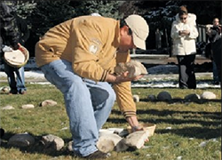 a volunteer gathers stones to make the medicine wheel