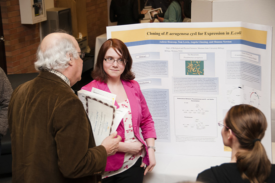 Biology and chemistry major Aubrey Honcoop discusses with Honors Program Director Dr. David Craig her science research during the 2014 Research and Creativity Conference. 