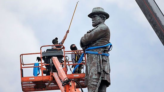 workers and a crane preparing to remove a Confederate monument