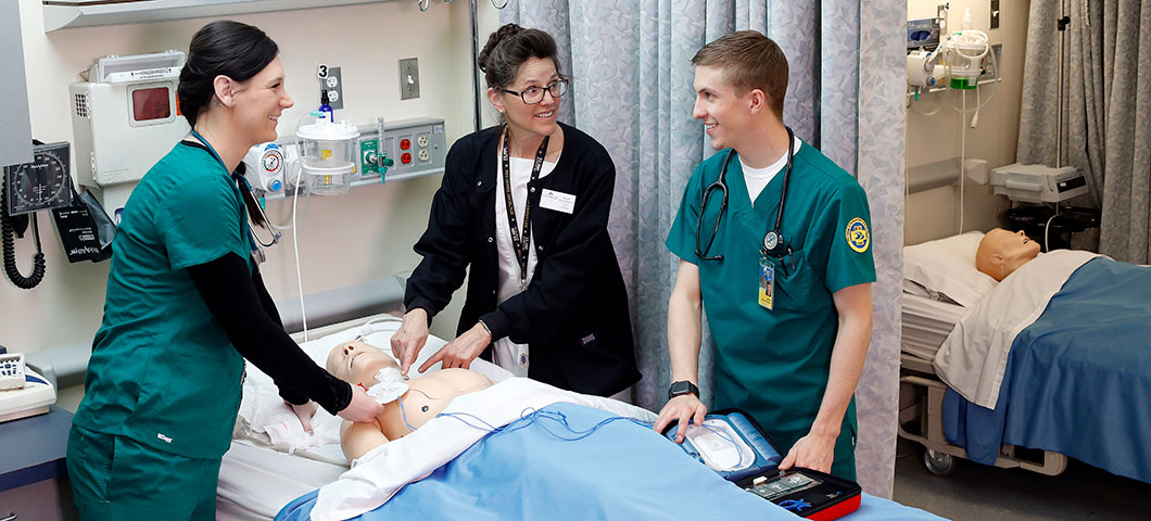 Nurses standing over a model