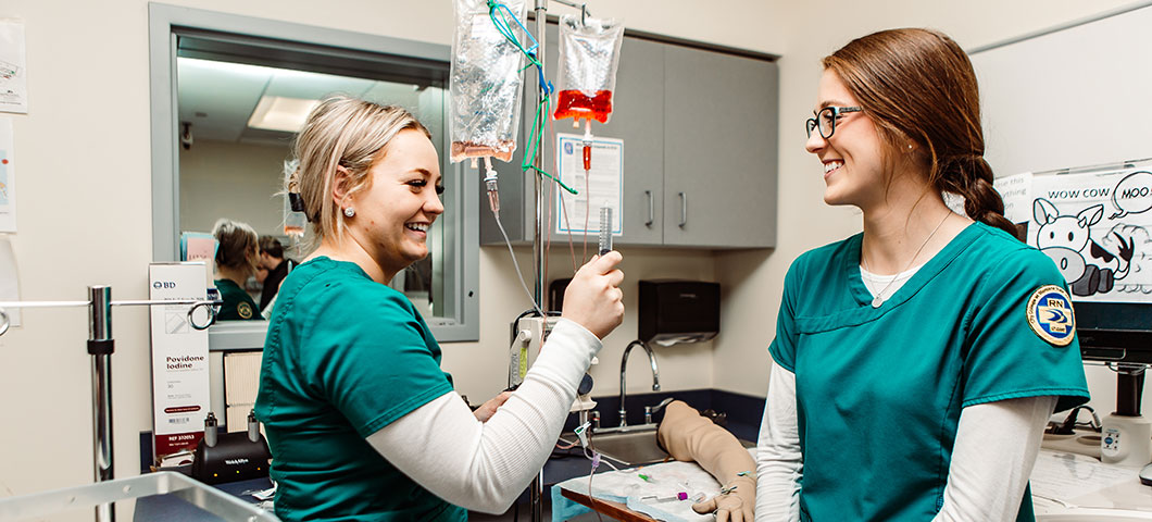 Nurses near an IV bag.