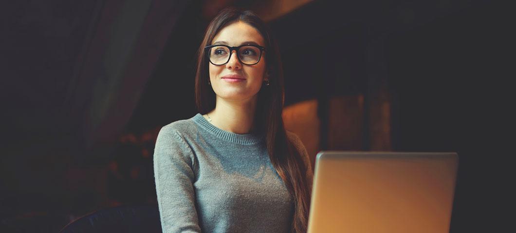 A student with glasses smiling.