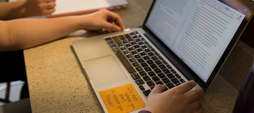 Student with laptop working on coursework