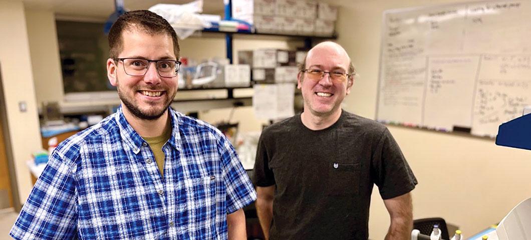 Two smiling men in a lab