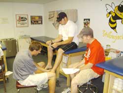 a student wraps an athlete's ankle