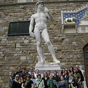 Student posing before an ancient statue