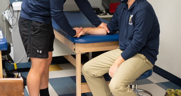 athletic trainer working with an athlete's arm