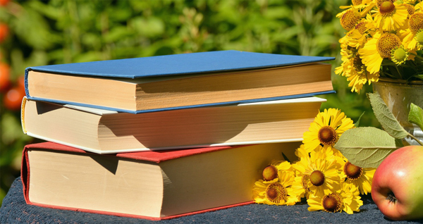 stack of books next to sunflowers