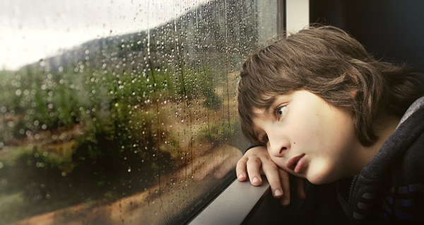 boy leaning on a window sill