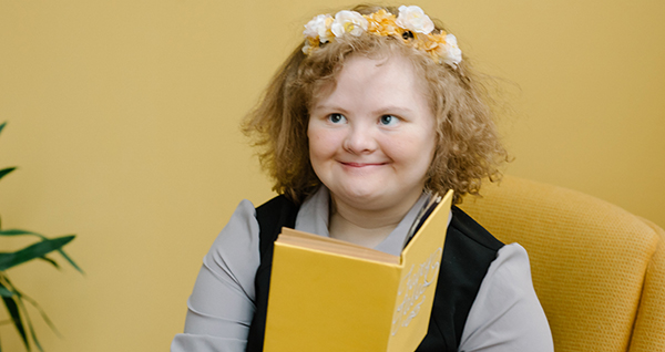 girl with Down Syndrome holding a book