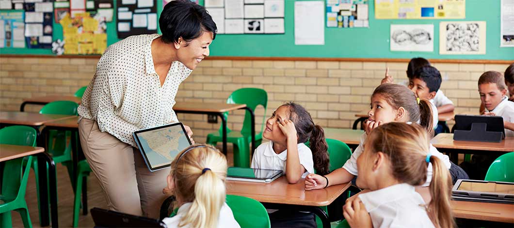 a teacher instructs her class using a tablet device.