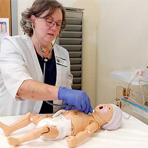 a nursing instructor demonstrates treating an infant