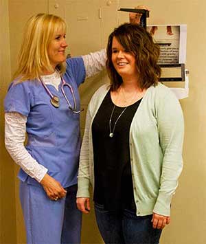 a nurseweighs and measures a MSUB student