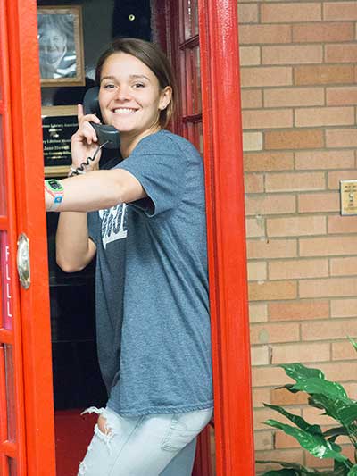student in the red phonebooth in the library