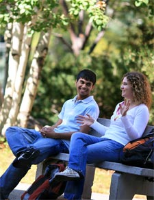 students sitting on a bench in Peaks to Plains Park on the MSUB main campus
