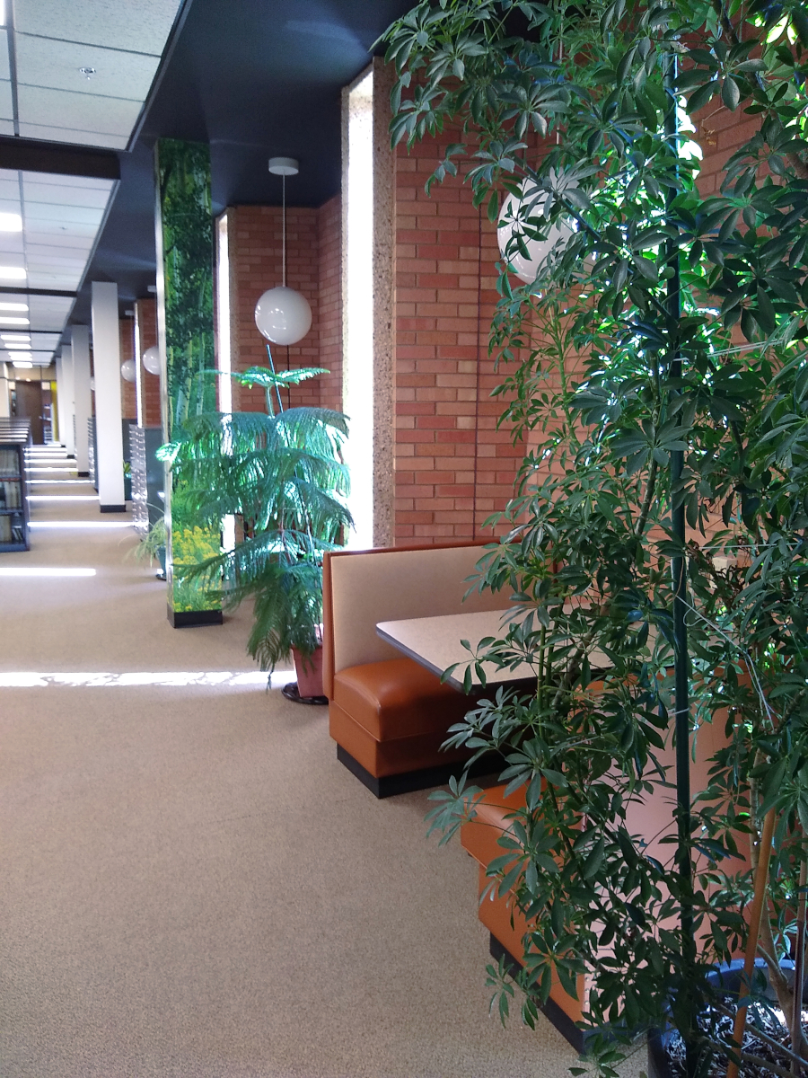 A booth between two potted plants in an alcove