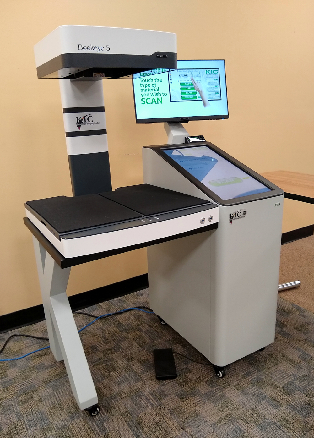 A modern scanner machine for books, with several screens.