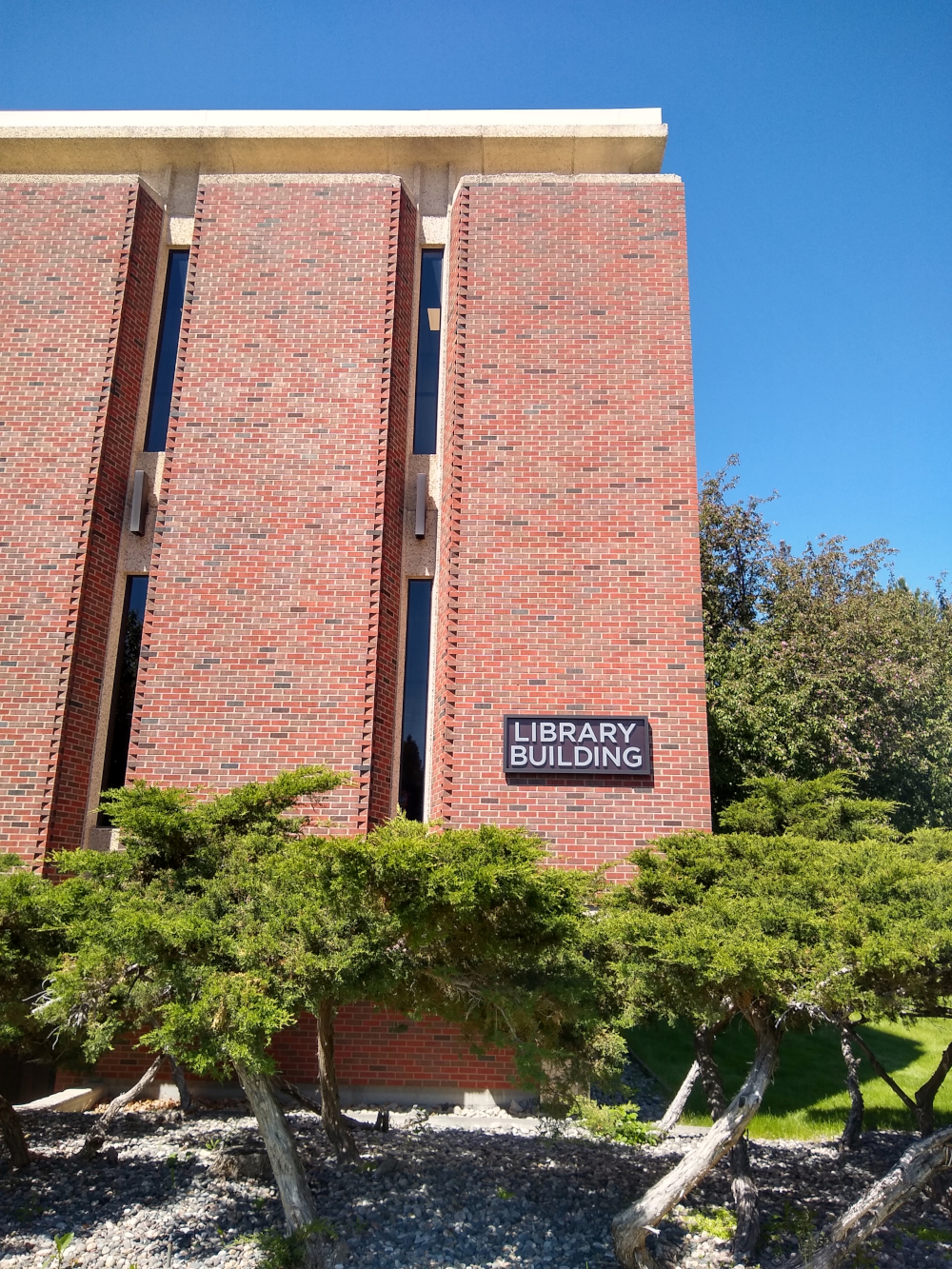 A tall, midcentury brick facade with a sign that reads "Library Building."