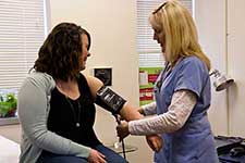 a clinic nurse takes a patient's blood pressure