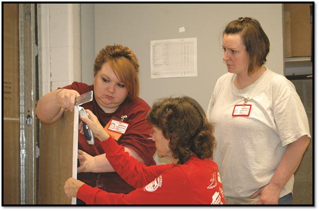 A representative from Habitat for Humanity works with two women at the Montana Women’s Prison during some hands-on construction training at the prison last fall.