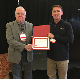 Kelly McCoy accepts the IFSAC Certificate of Accreditation