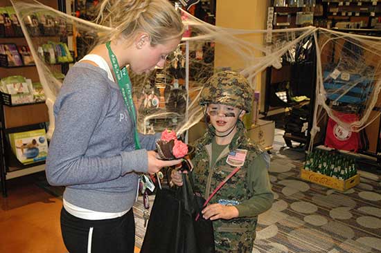 MSUB student helps a child with a Halloween game