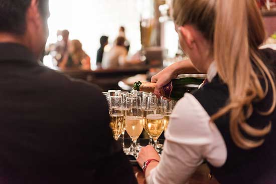 wait staff pouring a glass of champagne
