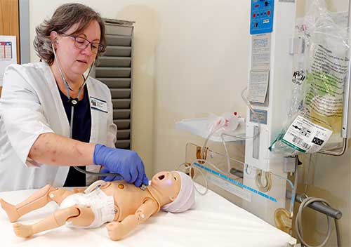 a nursing instructor demonstrates treating an infant