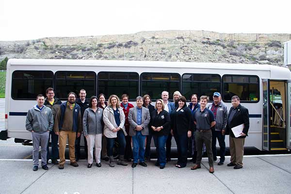 Group photo of MSUB faculty and staff in front of the MSUB bus